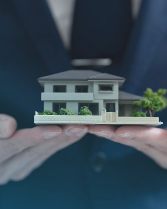 手のひらに載せた住宅の模型 - 住まいのセレクションサポート事業のイメージ
